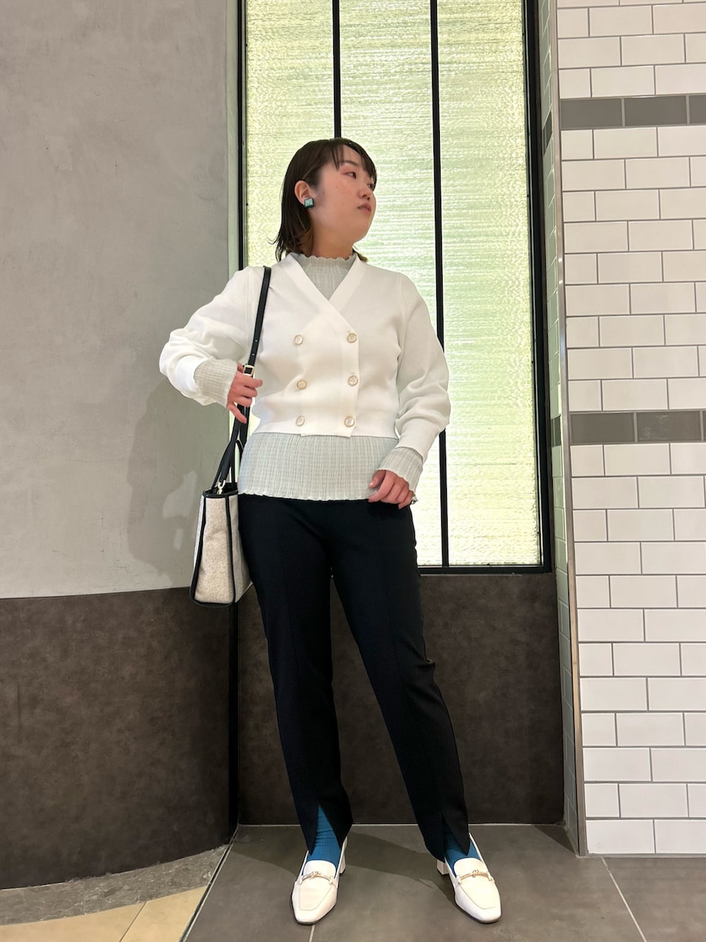 ホワイト系のカーディガン/ボレロ、グリーン系のTシャツ/カットソー、ブラック系のトートバッグを着用したレディースの春コーディネートの6枚目の写真