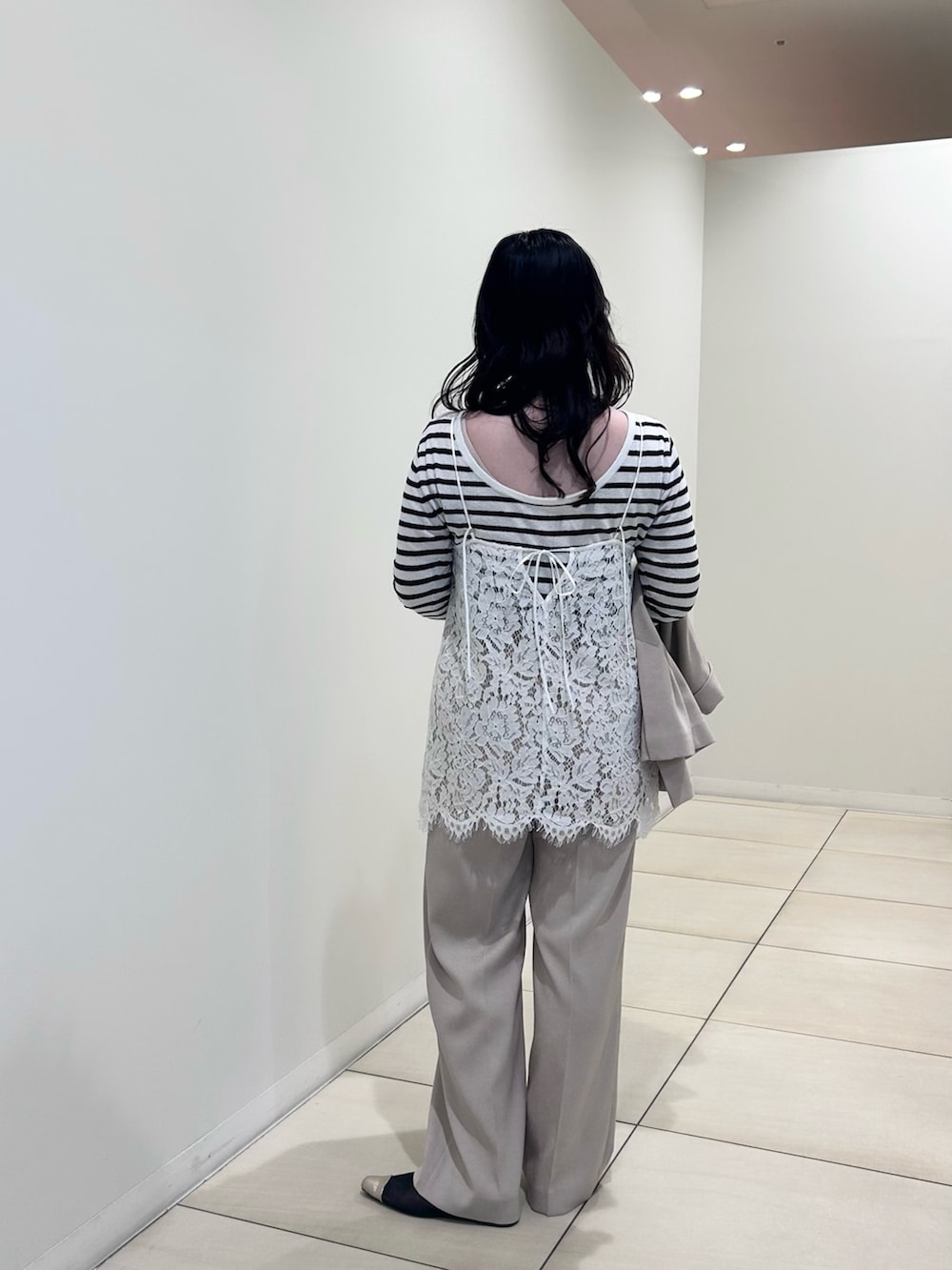 ホワイト系のキャミソール、ホワイト系のニット/セーター、ベージュ系のテーラードジャケットを着用したレディースの春コーディネートの3枚目の写真