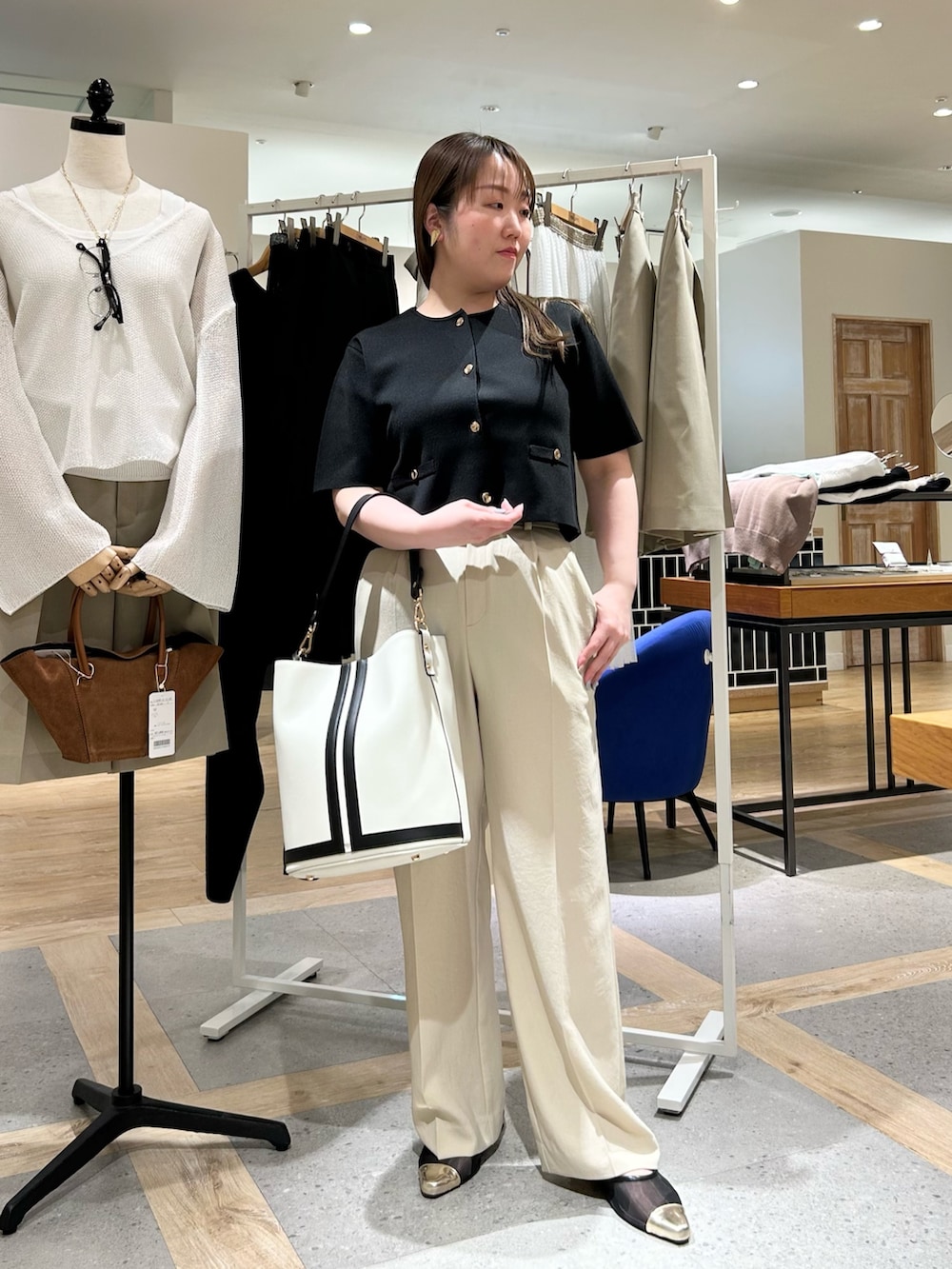 ブラック系のノーカラージャケット、ベージュ系のその他パンツ、ホワイト系のショルダーバッグを着用したレディースの夏コーディネートの8枚目の写真