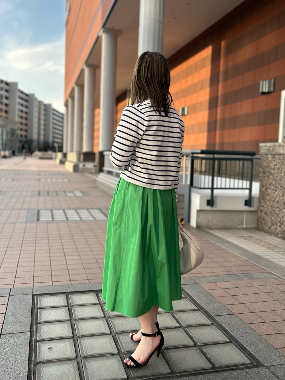 ホワイト系のカーディガン/ボレロ、グリーン系のスカート、ホワイト系のTシャツ/カットソーを着用したレディースの冬コーディネートの5枚目の写真