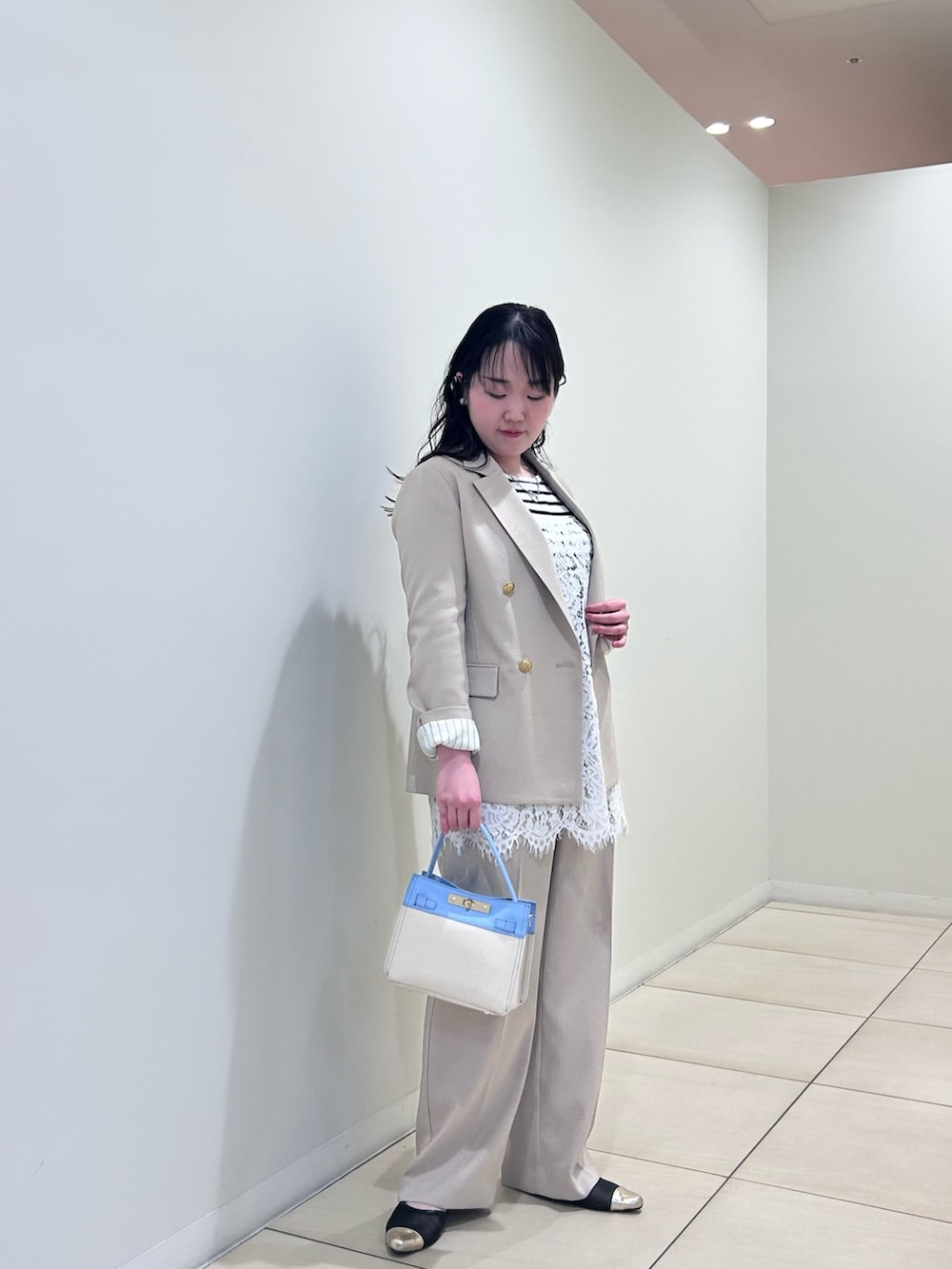 ベージュ系のテーラードジャケット、ベージュ系のその他パンツ、ホワイト系のニット/セーターを着用したレディースの春コーディネートの5枚目の写真