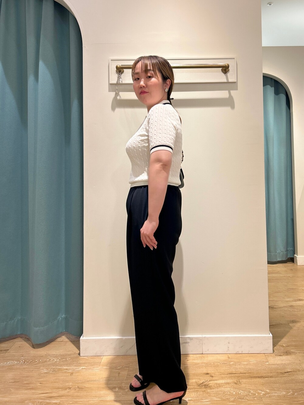 ホワイト系のニット/セーター、ブルー系のその他パンツ、ブラック系のショルダーバッグを着用したレディースの夏コーディネートの8枚目の写真