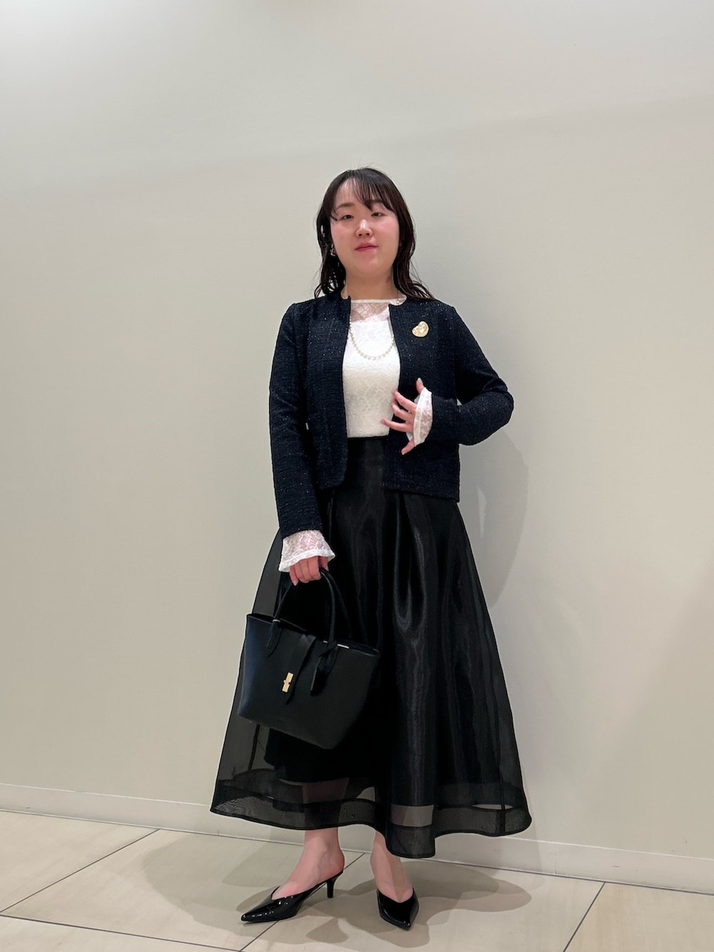 ブルー系のノーカラージャケット、ブラック系のスカート、ホワイト系のTシャツ/カットソーを着用したレディースの春コーディネートの7枚目の写真