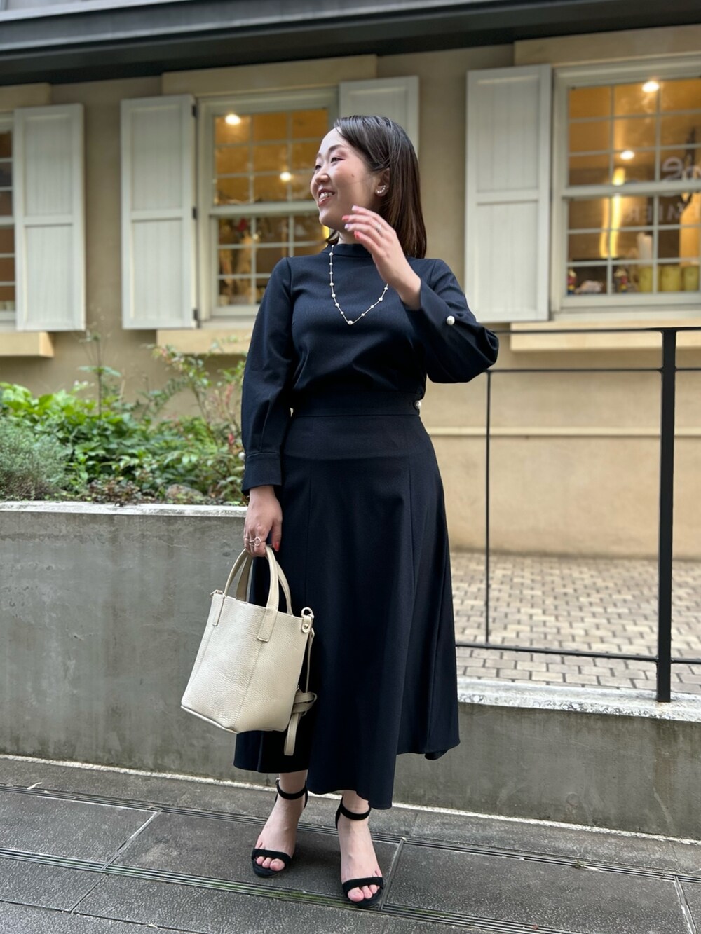 ブルー系のシャツ/ブラウス、ブルー系のスカート、ホワイト系のトートバッグを着用したレディースの秋コーディネートの9枚目の写真