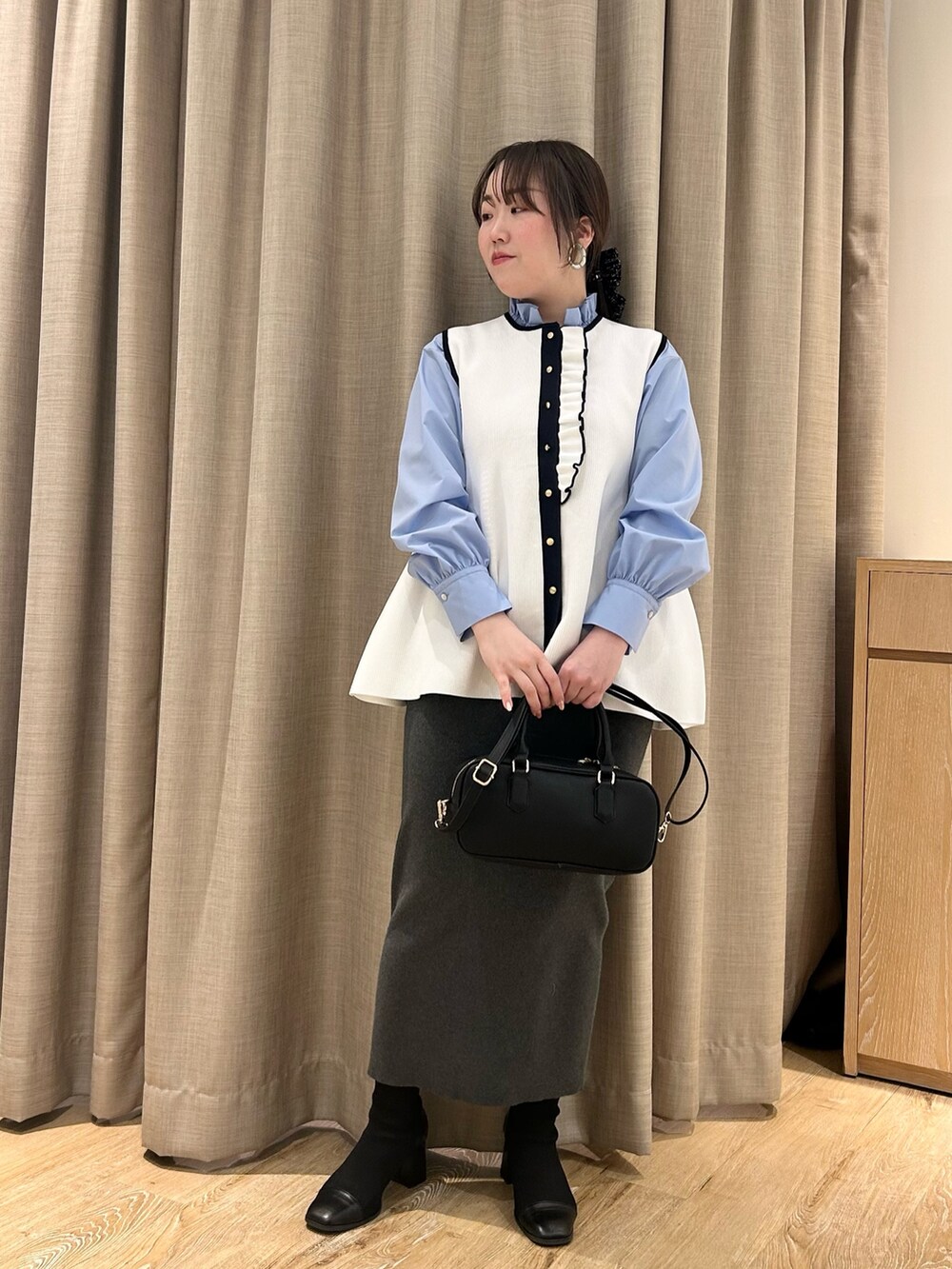 ホワイト系のベスト、ブルー系のシャツ/ブラウス、グレー系のスカートを着用したレディースの冬コーディネートの8枚目の写真