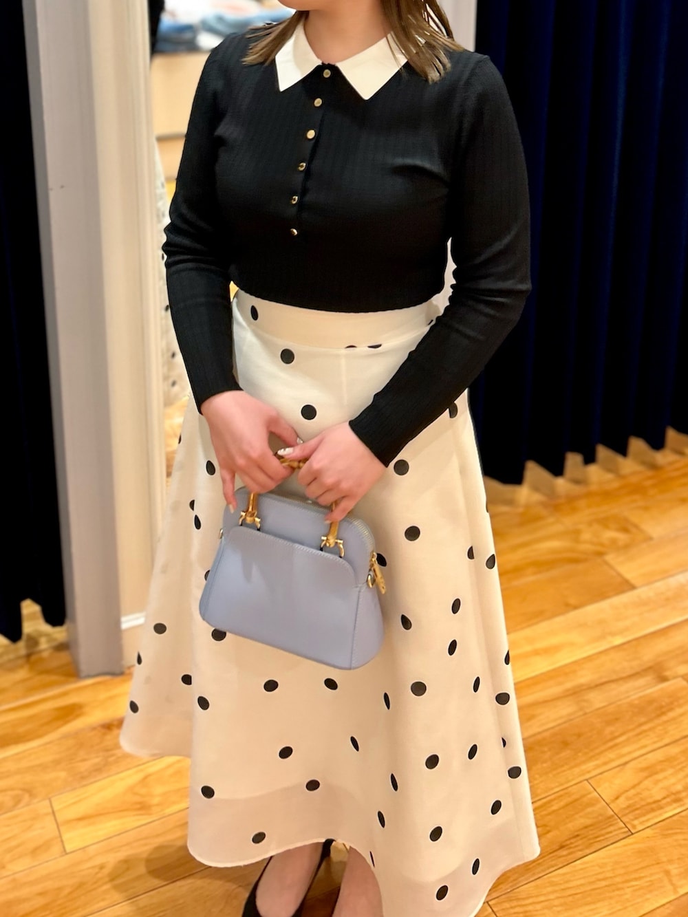 ブラック系のニット/セーター、ホワイト系のスカート、ブルー系のショルダーバッグを着用したレディースの冬コーディネートの10枚目の写真