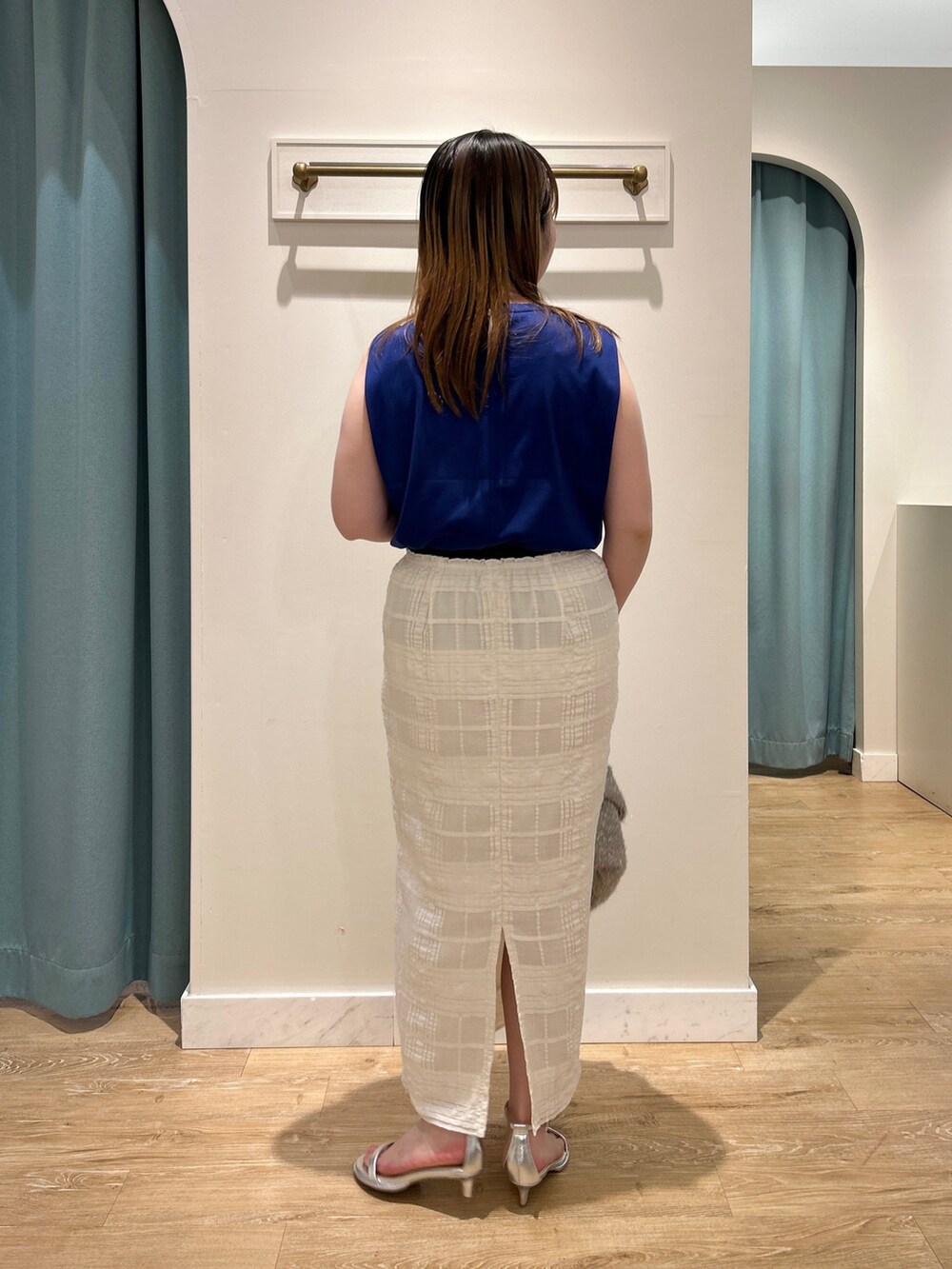 ブルー系のTシャツ/カットソー、ホワイト系のスカート、ベージュ系のバックパック/リュックを着用したレディースの夏コーディネートの8枚目の写真