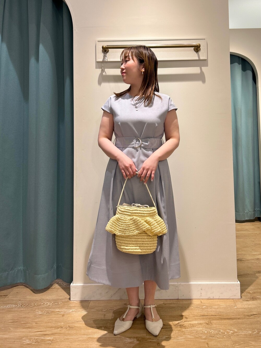 ブルー系のワンピース、ベージュ系のかごバッグ、シルバー系のネックレスを着用したレディースの夏コーディネートの6枚目の写真