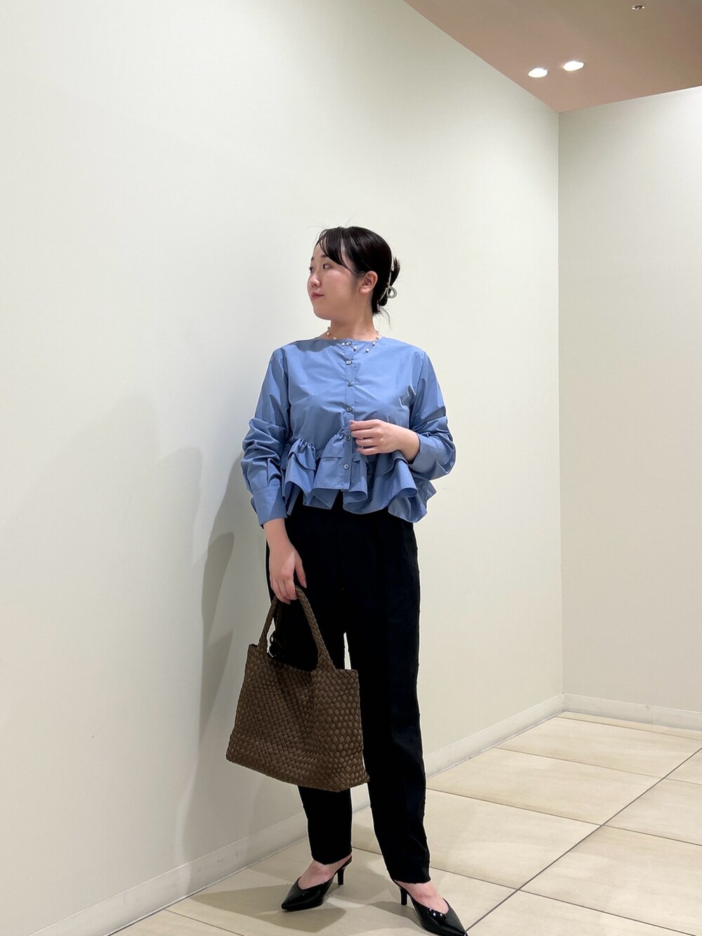 ブルー系のシャツ/ブラウス、ブラック系のその他パンツ、ブラウン系のトートバッグを着用したレディースの秋コーディネートの7枚目の写真