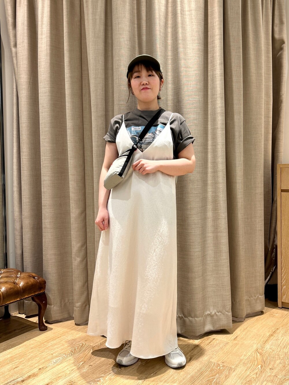 グレー系のTシャツ/カットソー、ホワイト系のワンピース、ベージュ系のショルダーバッグを着用したレディースの春コーディネートの2枚目の写真