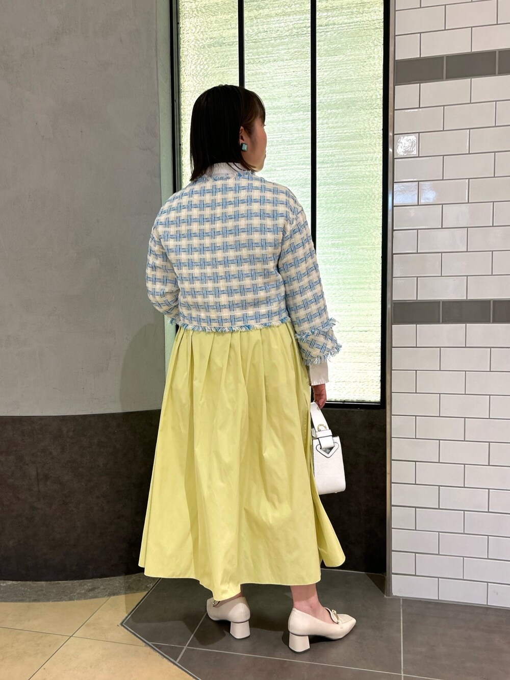 ブルー系のノーカラージャケット、ホワイト系のシャツ/ブラウス、ホワイト系のショルダーバッグを着用したレディースの冬コーディネートの5枚目の写真