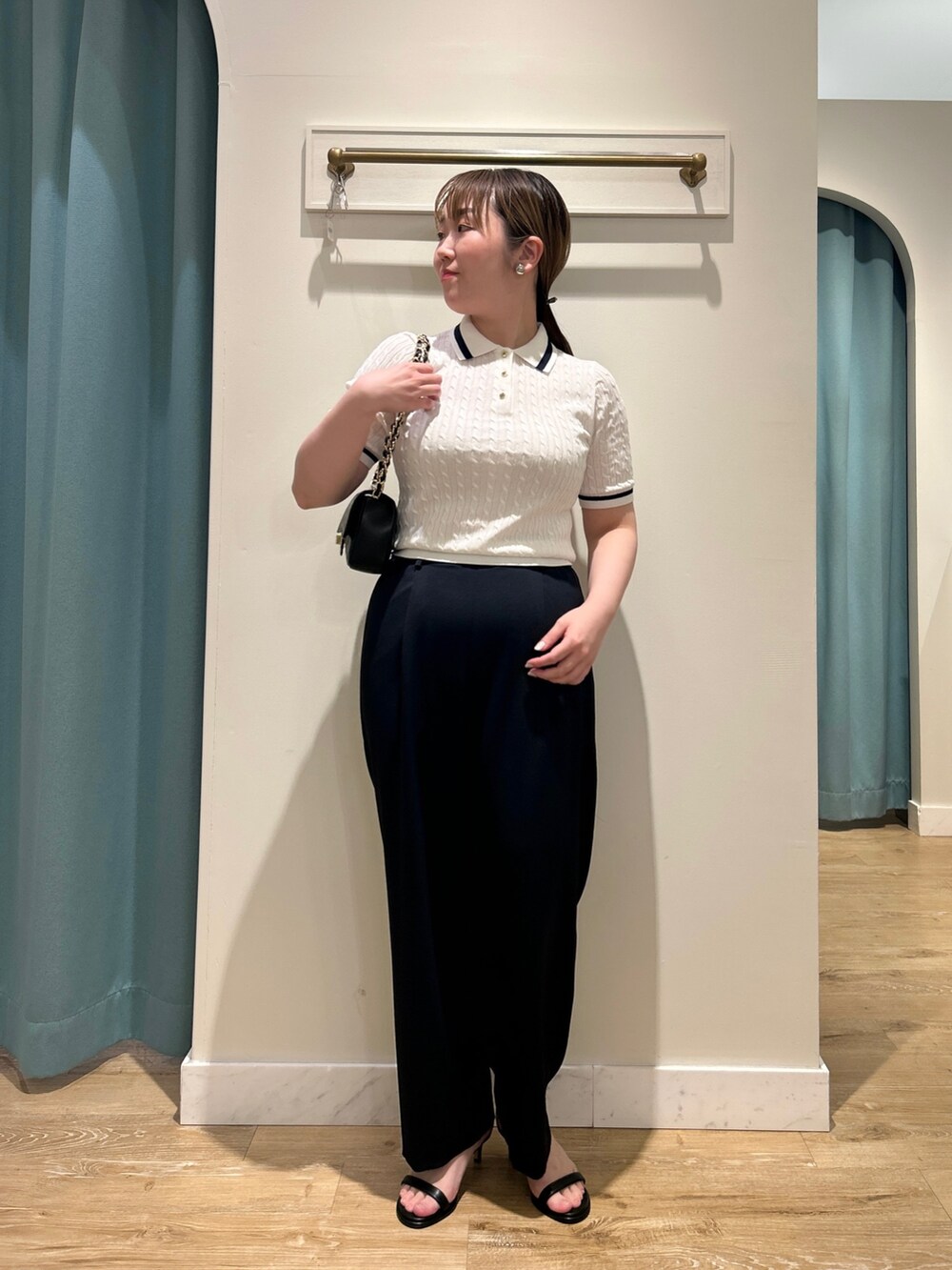 ホワイト系のニット/セーター、ブルー系のその他パンツ、ブラック系のショルダーバッグを着用したレディースの夏コーディネートの3枚目の写真