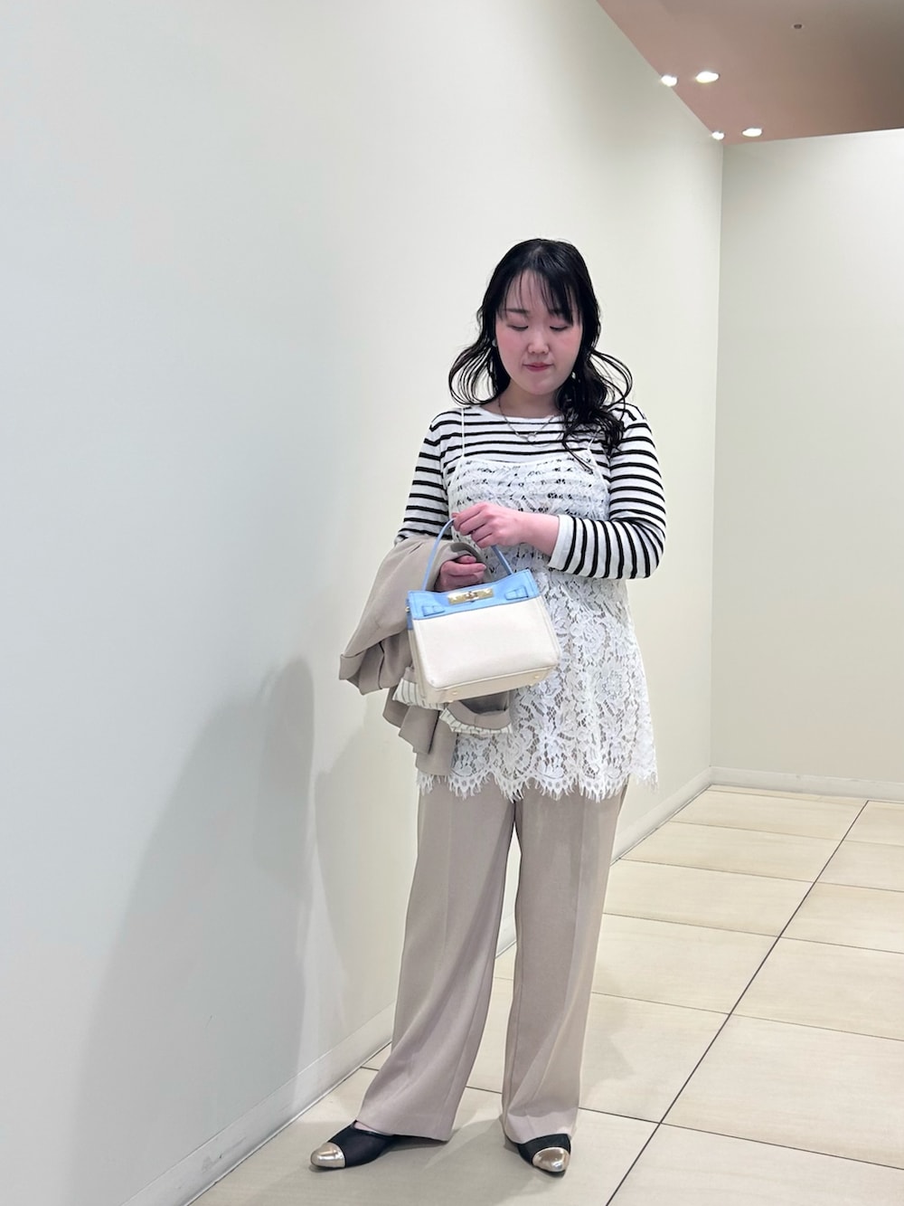 ホワイト系のキャミソール、ホワイト系のニット/セーター、ベージュ系のテーラードジャケットを着用したレディースの春コーディネートの8枚目の写真