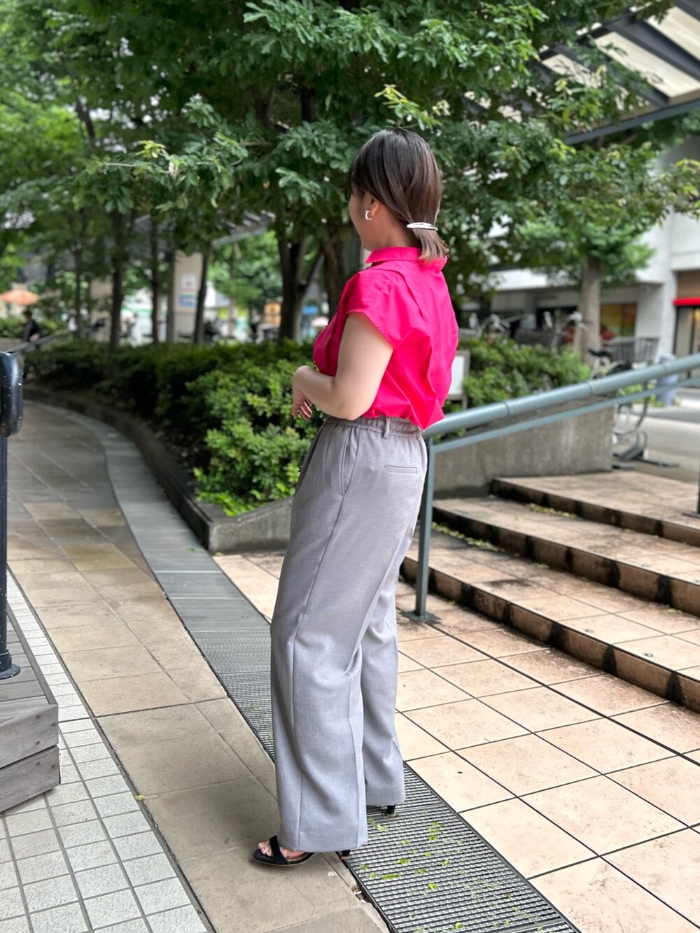 ピンク系のシャツ/ブラウス、ブラック系のトートバッグ、グレー系のその他パンツを着用したレディースの夏コーディネートの3枚目の写真