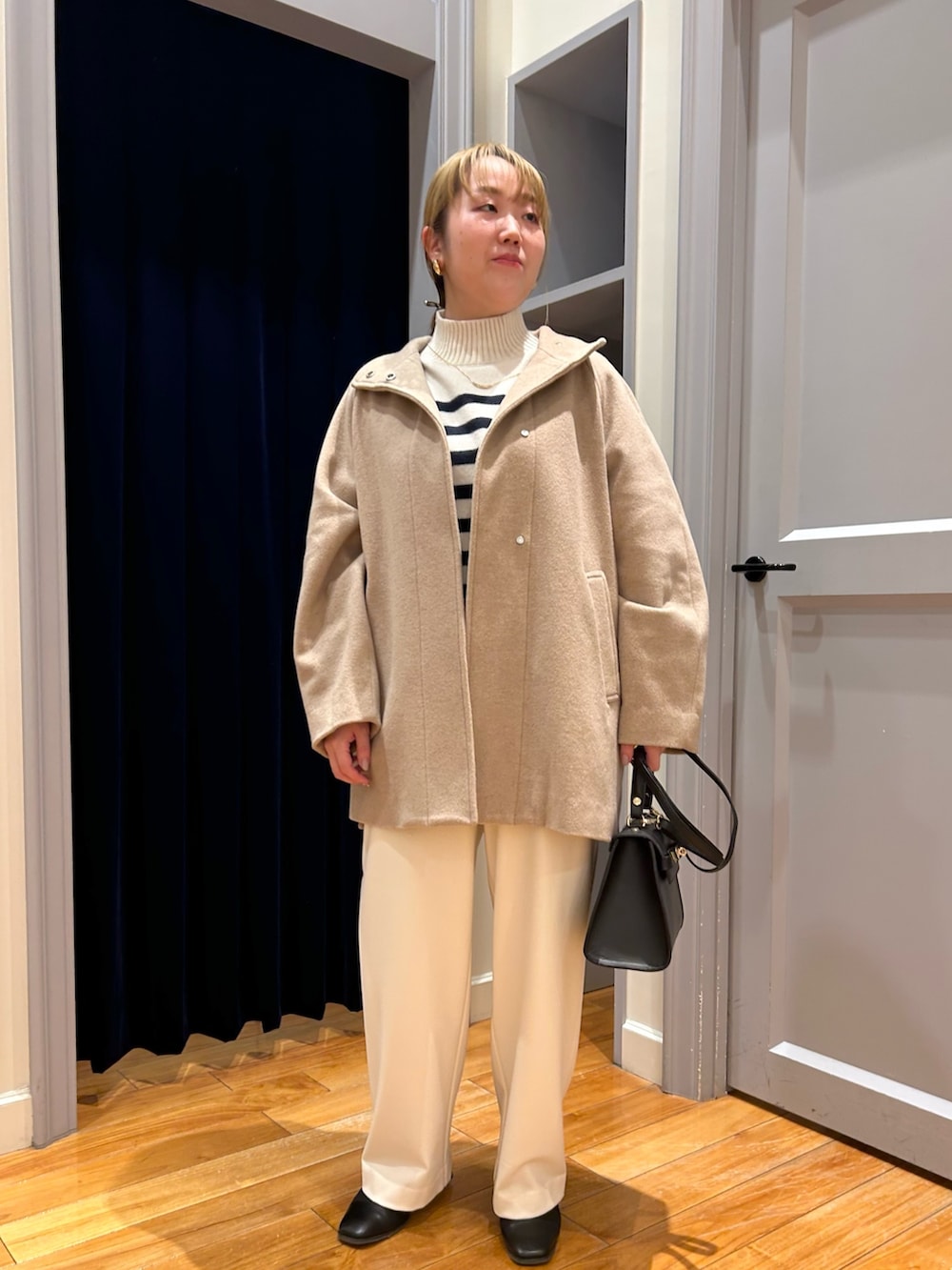 ベージュ系のその他アウター、ホワイト系のその他パンツ、ブルー系のニット/セーターを着用したレディースの冬コーディネートの7枚目の写真