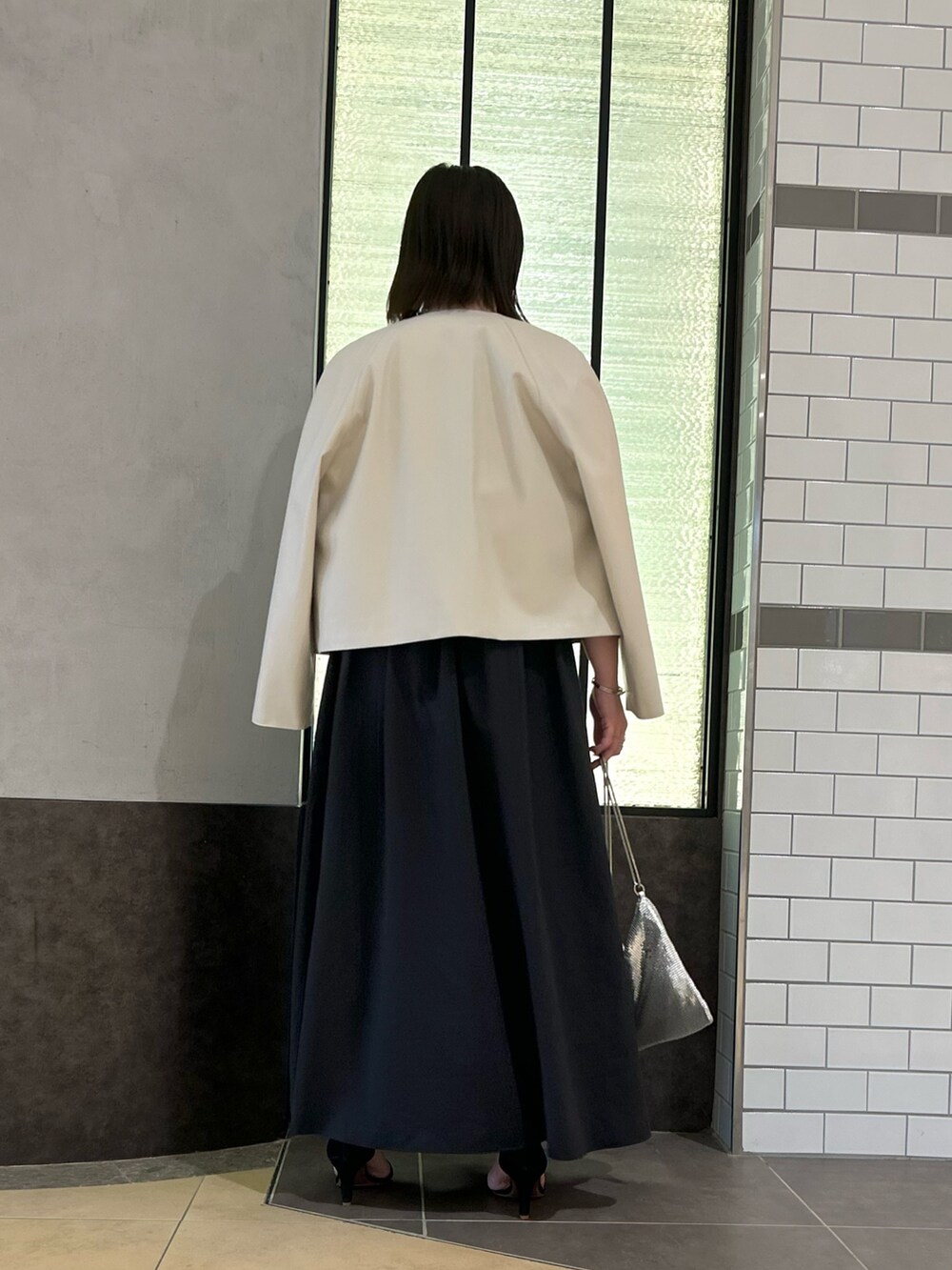 ベージュ系のブルゾン、レッド系のTシャツ/カットソー、ブラック系のスカートを着用したレディースの秋コーディネートの4枚目の写真