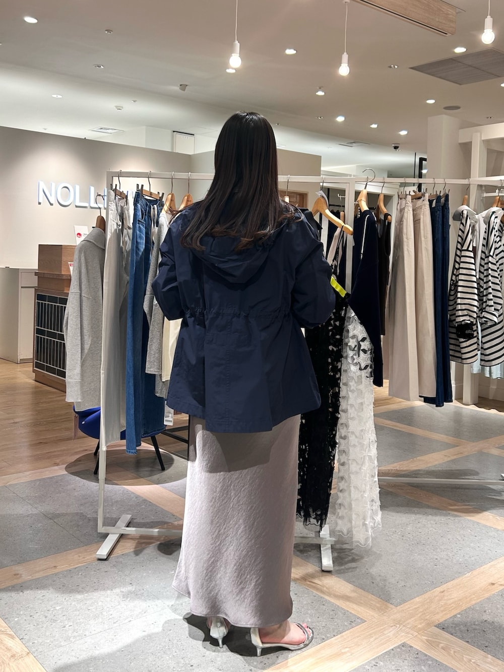 ホワイト系のカーディガン/ボレロ、グリーン系のスカート、ブルー系のブルゾンを着用したレディースの春コーディネートの3枚目の写真