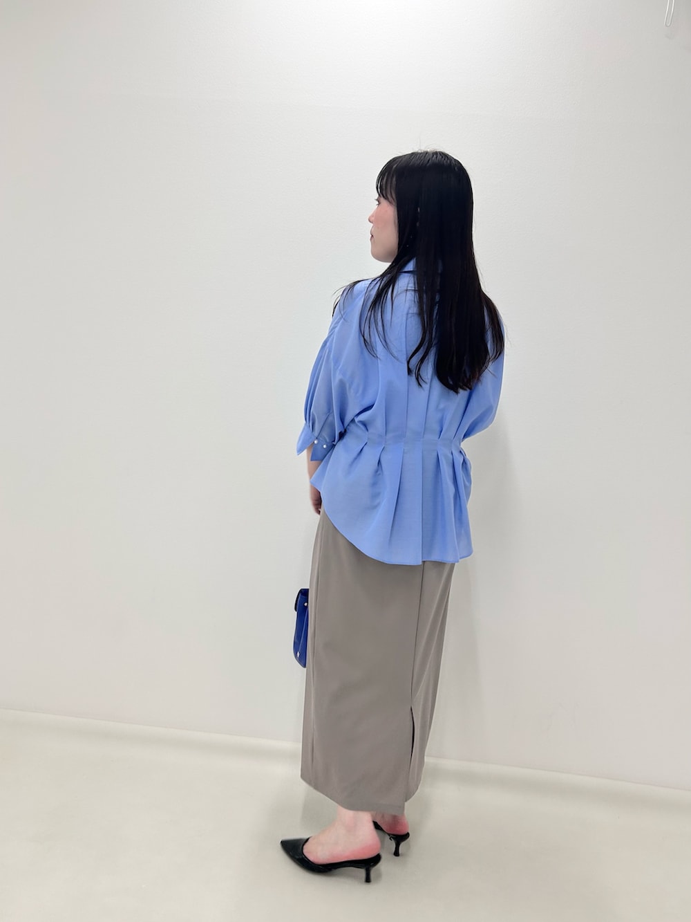ベージュ系のスカート、ブルー系のシャツ/ブラウスを着用したレディースの夏コーディネートの3枚目の写真
