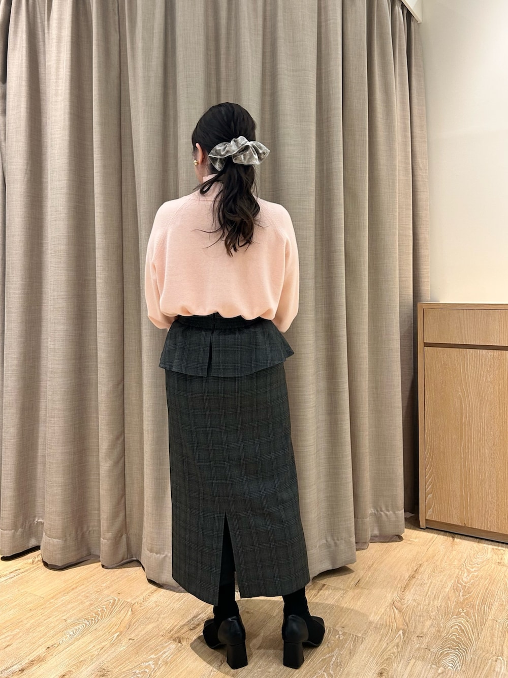 ピンク系のニット/セーター、ブラック系のスカート、ベージュ系のトートバッグを着用したレディースの冬コーディネートの3枚目の写真