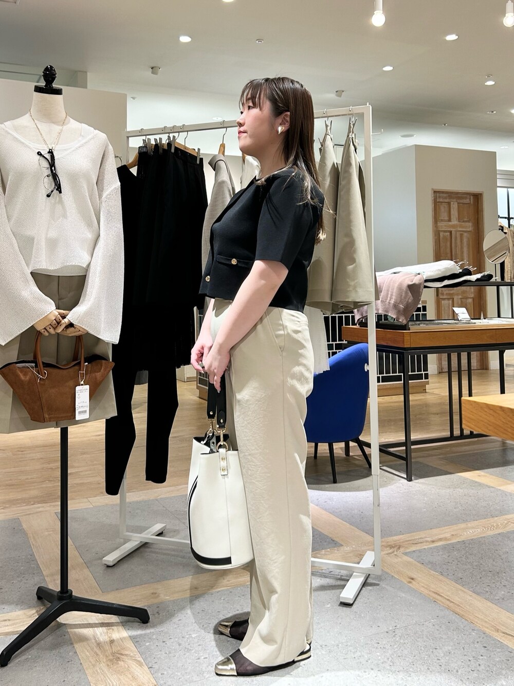 ブラック系のノーカラージャケット、ベージュ系のその他パンツ、ホワイト系のショルダーバッグを着用したレディースの夏コーディネートの2枚目の写真