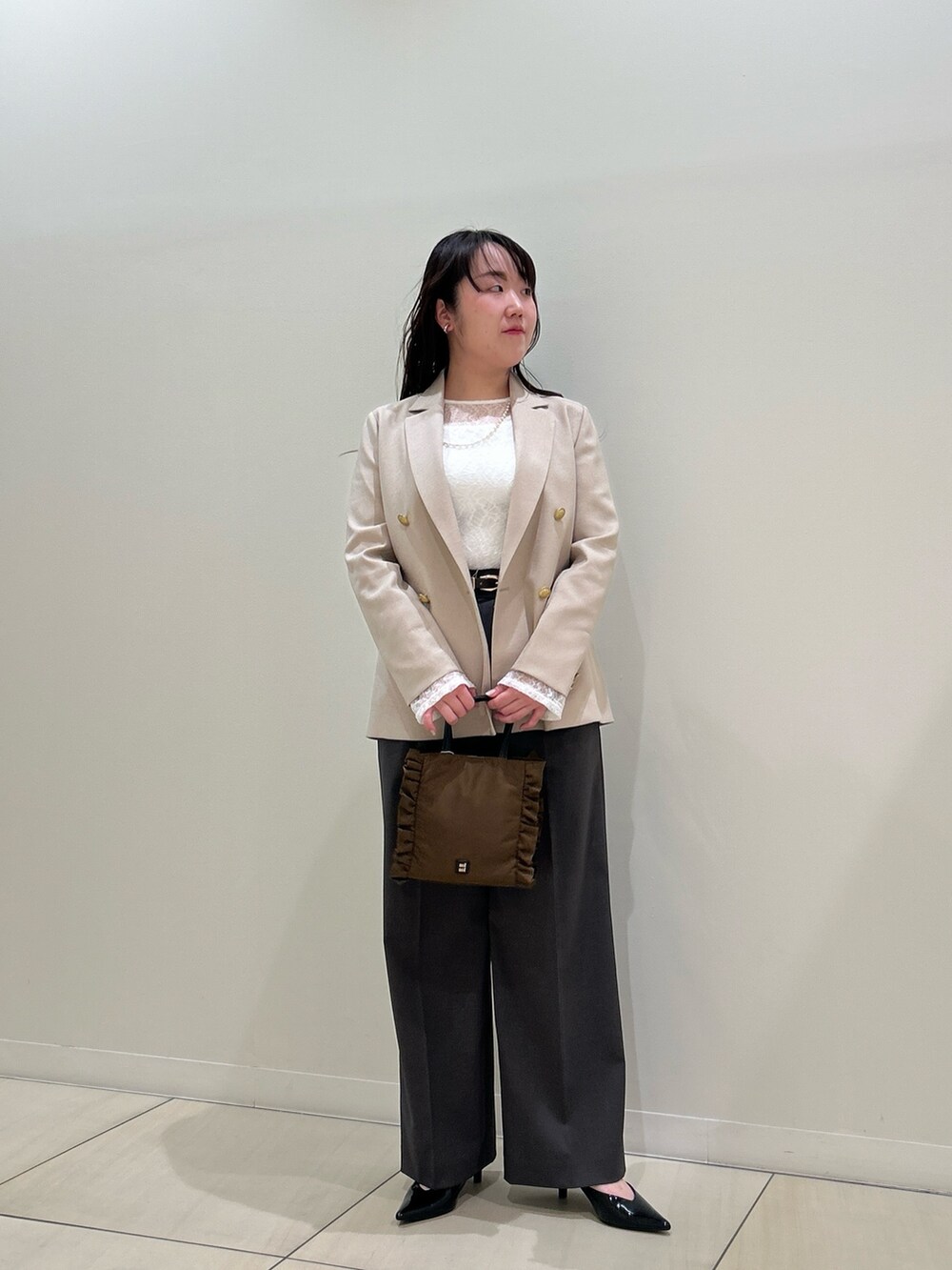ベージュ系のテーラードジャケット、グレー系のその他パンツ、ホワイト系のTシャツ/カットソーを着用したレディースの春コーディネートの5枚目の写真