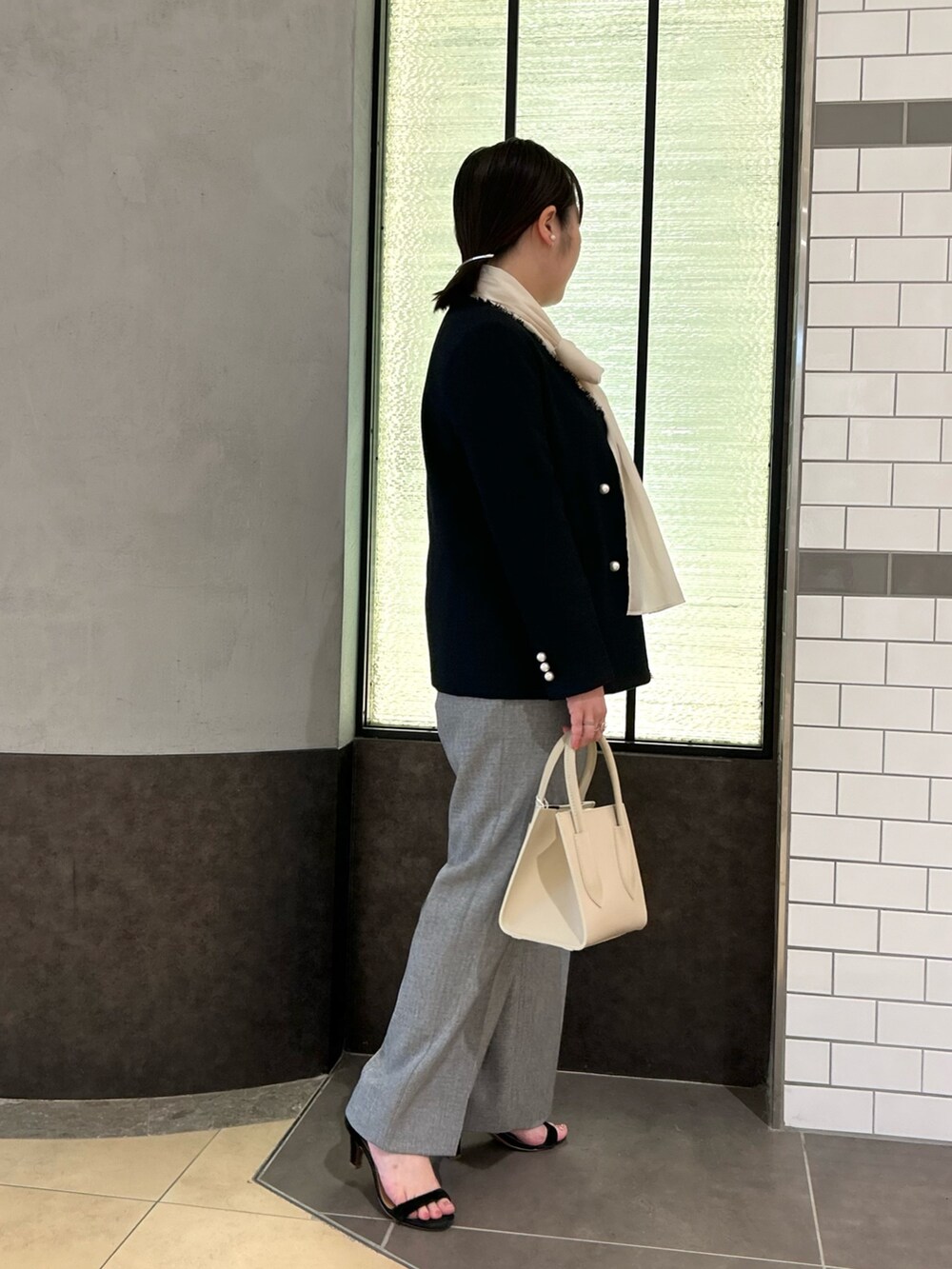 ブルー系のノーカラージャケット、ホワイト系のシャツ/ブラウス、グレー系のその他パンツを着用したレディースの秋コーディネートの4枚目の写真