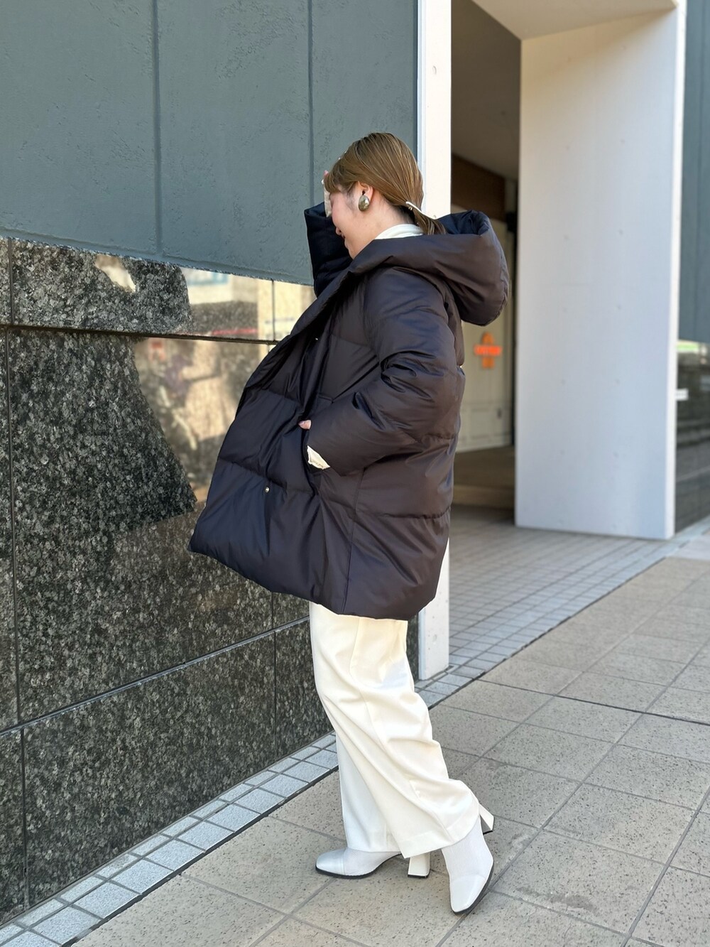 ブラック系のダウンジャケット/コート、グレー系のカーディガン/ボレロ、ホワイト系のTシャツ/カットソーを着用したレディースの冬コーディネートの3枚目の写真