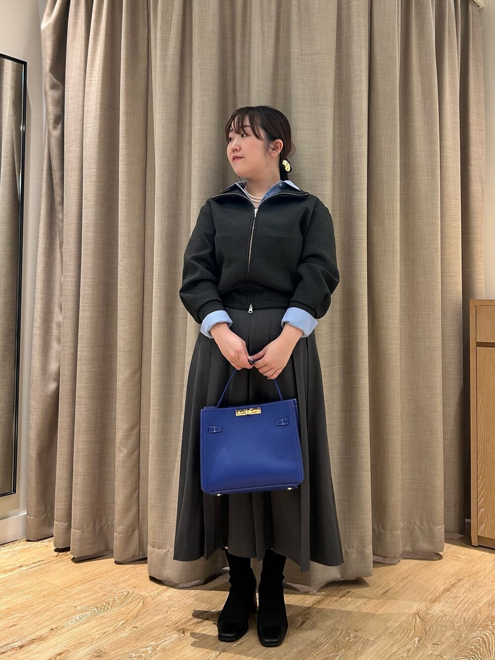 グレー系のブルゾン、ブルー系のシャツ/ブラウス、グレー系のスカートを着用したレディースの秋コーディネートの6枚目の写真