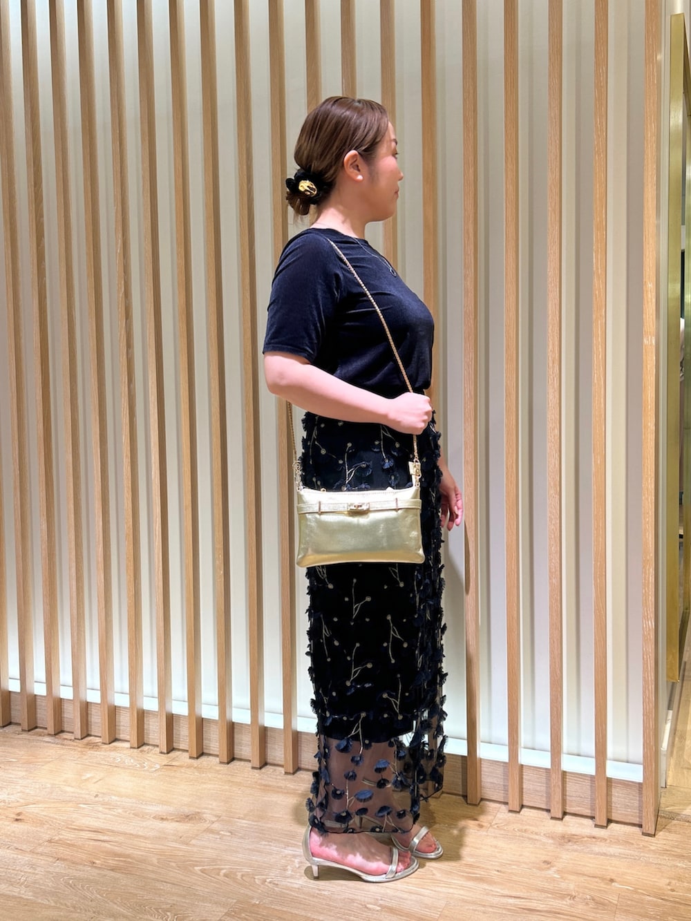 ブルー系のTシャツ/カットソー、ブルー系のスカート、ゴールド系のショルダーバッグを着用したレディースの秋コーディネートの4枚目の写真