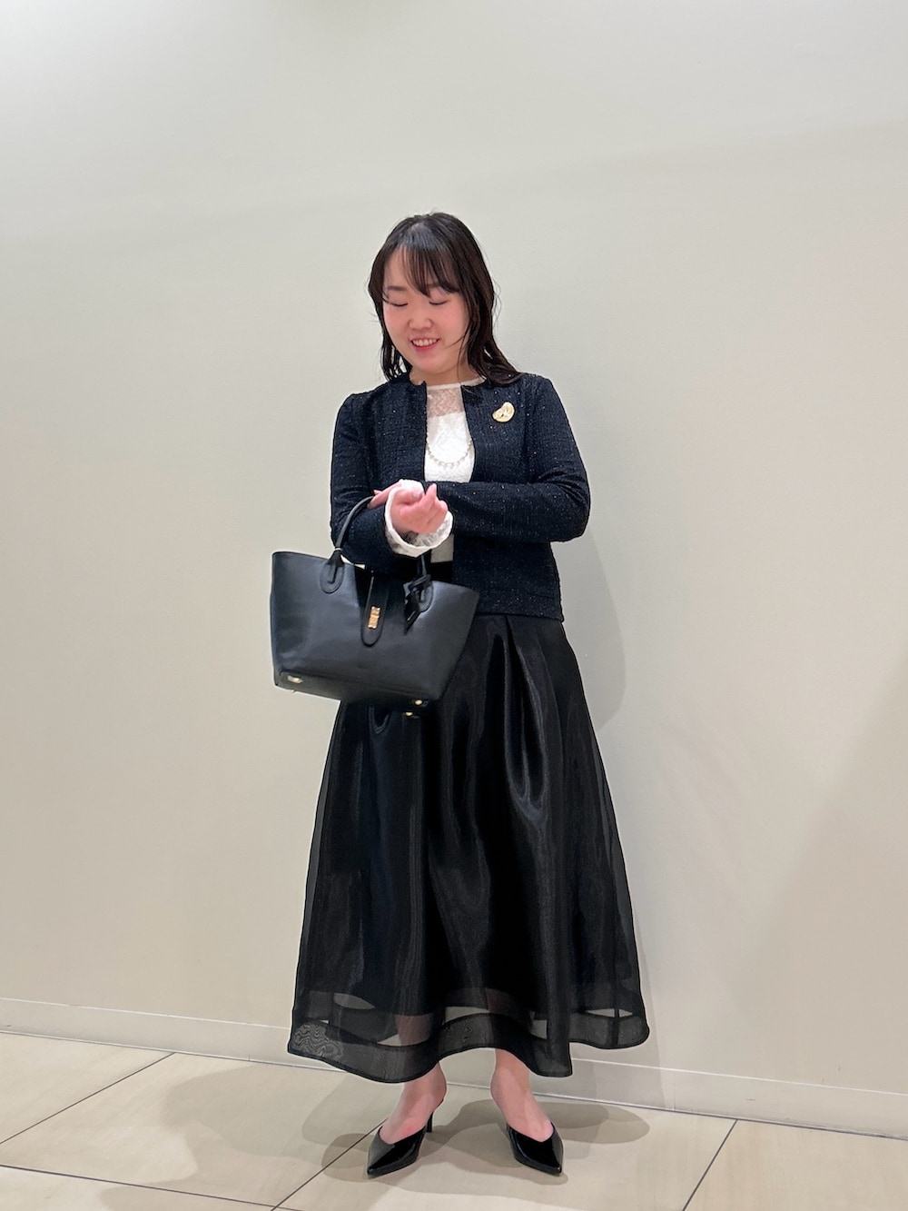 ブルー系のノーカラージャケット、ブラック系のスカート、ホワイト系のTシャツ/カットソーを着用したレディースの春コーディネートの6枚目の写真