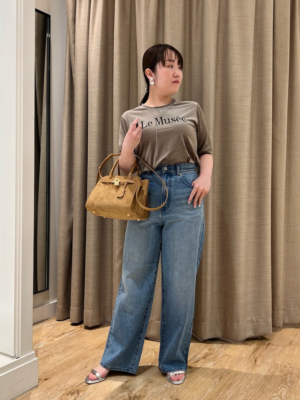 グリーン系のTシャツ/カットソー、ブルー系のデニムパンツ、イエロー系のトートバッグを着用したレディースの秋コーディネートの6枚目の写真
