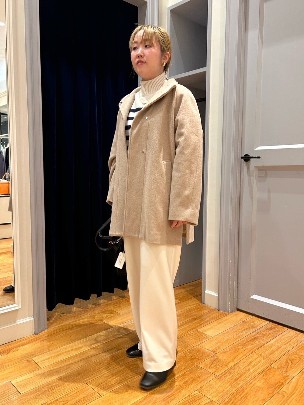 ベージュ系のその他アウター、ホワイト系のその他パンツ、ブルー系のニット/セーターを着用したレディースの冬コーディネートの2枚目の写真