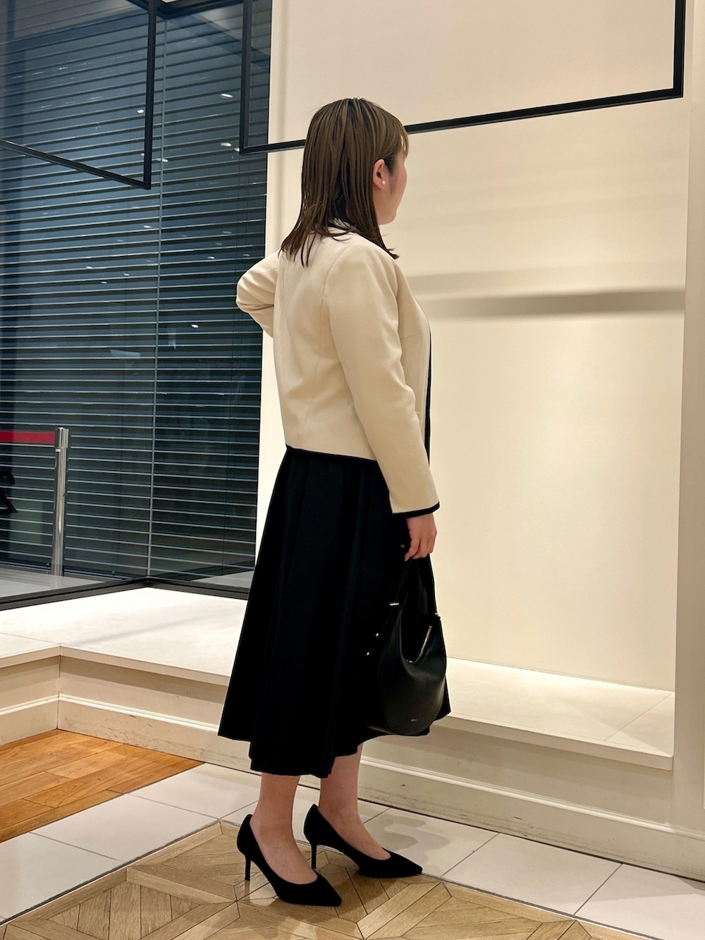 ホワイト系のノーカラージャケット、ホワイト系のシャツ/ブラウス、ブラック系のショルダーバッグを着用したレディースの冬コーディネートの5枚目の写真