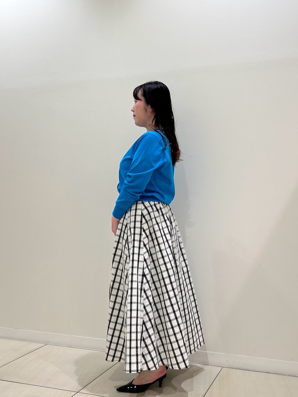 ブルー系のカーディガン/ボレロ、ホワイト系のスカート、ブラウン系のショルダーバッグを着用したレディースの春コーディネートの2枚目の写真