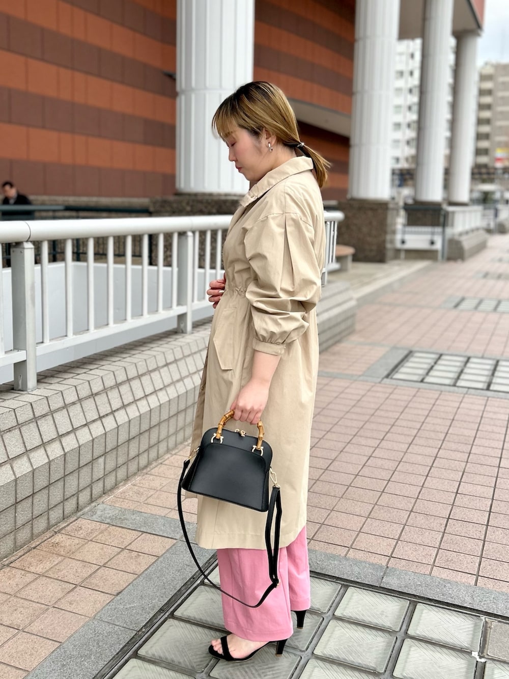 ベージュ系のその他アウター、ブラック系のニット/セーター、ピンク系のチノパンツを着用したレディースの春コーディネートの4枚目の写真