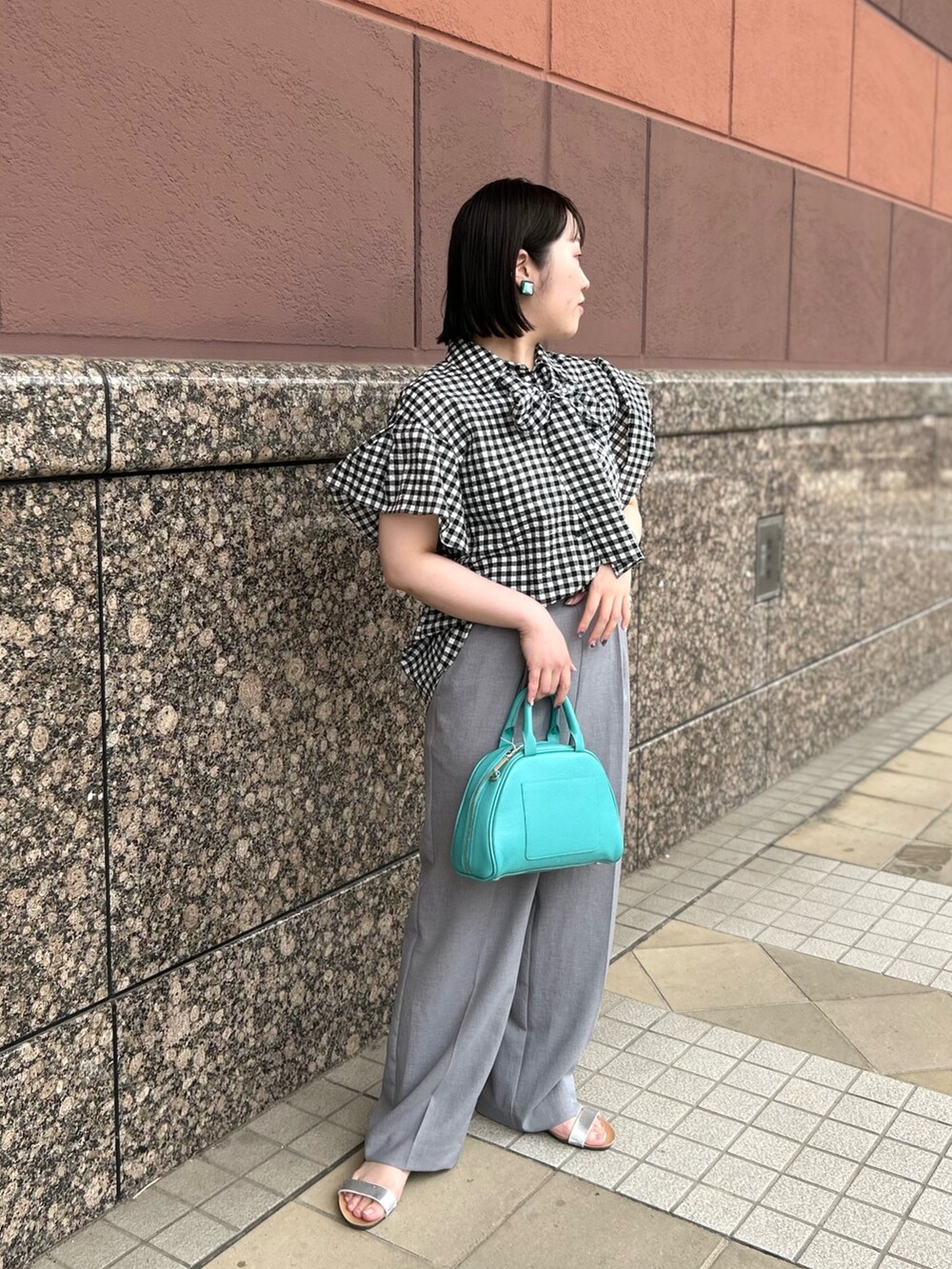 ブラック系のシャツ/ブラウス、グリーン系のボストンバッグ、グレー系のその他パンツを着用したレディースの夏コーディネートの3枚目の写真