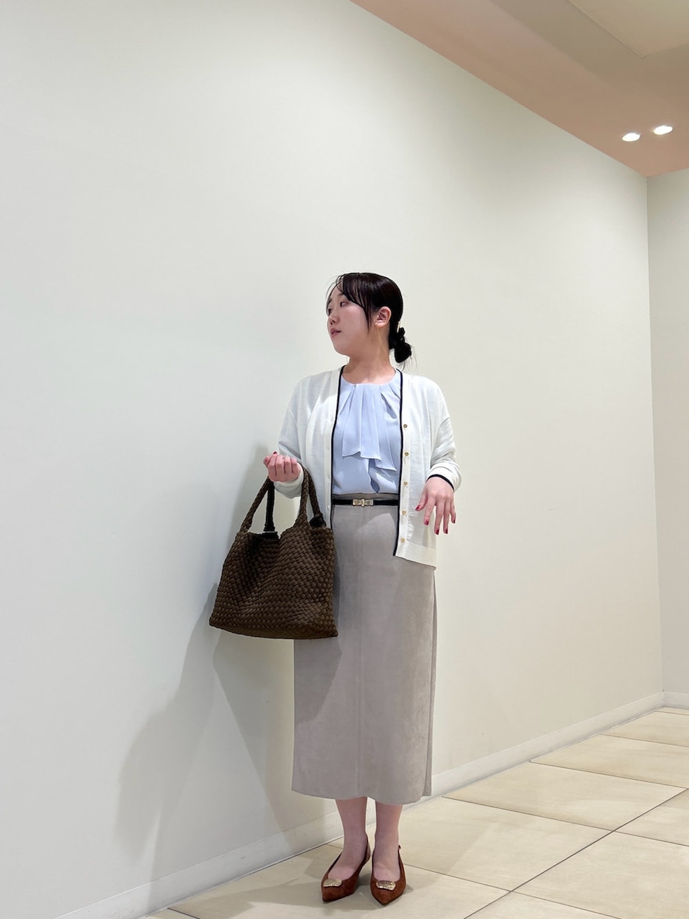 ホワイト系のカーディガン/ボレロ、ブルー系のシャツ/ブラウス、ベージュ系のスカートを着用したレディースの秋コーディネートの10枚目の写真