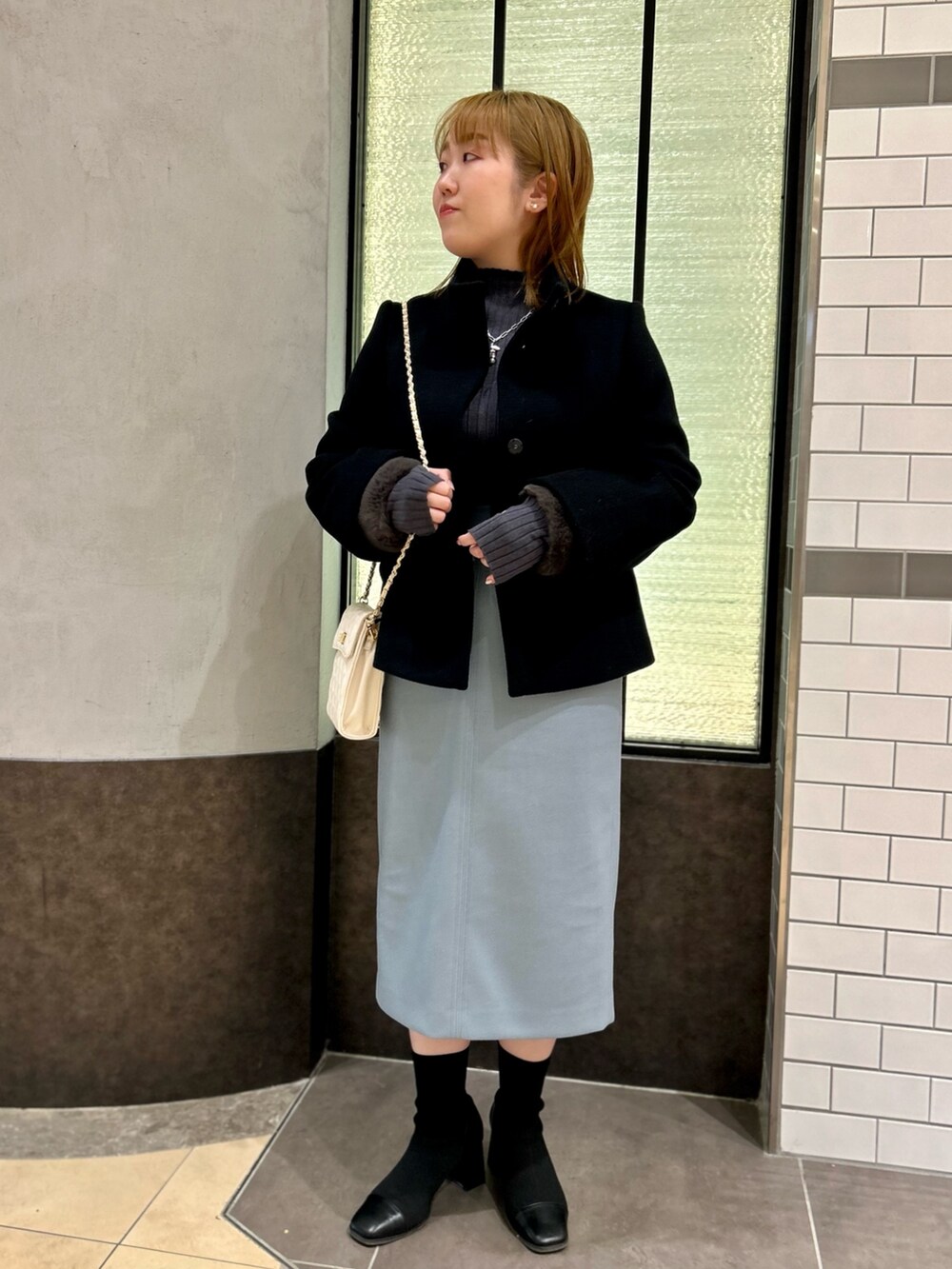 ブラック系のその他アウター、グレー系のニット/セーター、ブルー系のスカートを着用したレディースの冬コーディネートの5枚目の写真