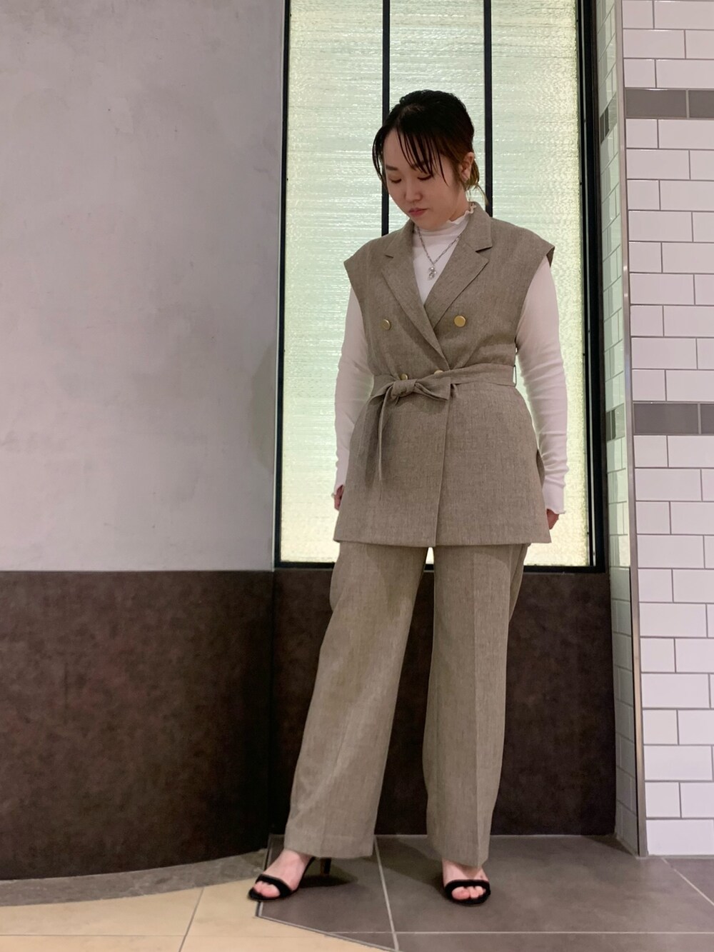 ベージュ系のベスト、ベージュ系のその他パンツ、ホワイト系のTシャツ/カットソーを着用したレディースの冬コーディネートの4枚目の写真