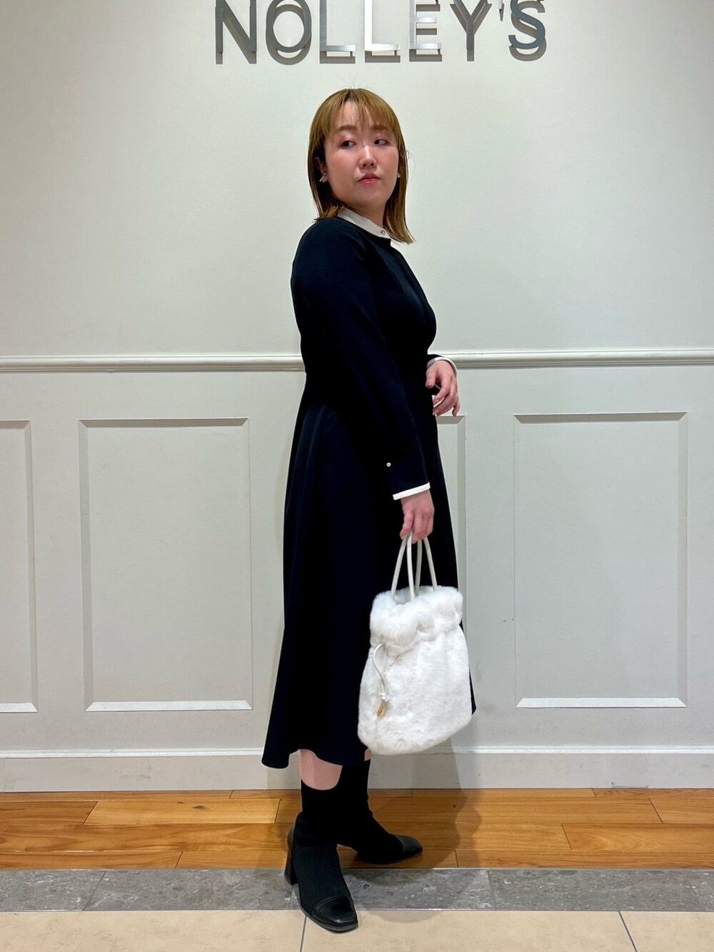 ブルー系のワンピース、ホワイト系のショルダーバッグ、ホワイト系のイヤリングを着用したレディースの冬コーディネートの7枚目の写真