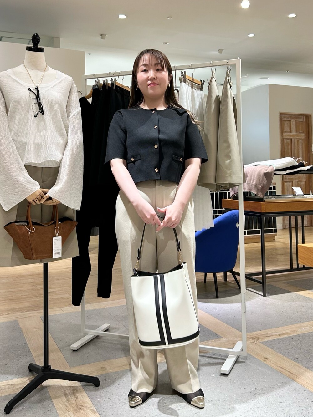 ブラック系のノーカラージャケット、ベージュ系のその他パンツ、ホワイト系のショルダーバッグを着用したレディースの夏コーディネートの7枚目の写真