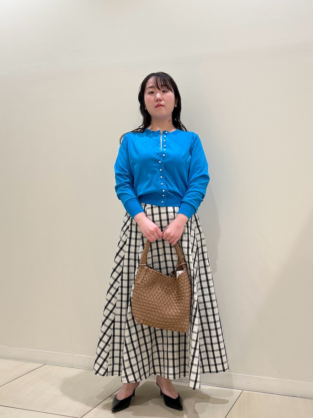 ブルー系のカーディガン/ボレロ、ホワイト系のスカート、ブラウン系のショルダーバッグを着用したレディースの春コーディネートの5枚目の写真
