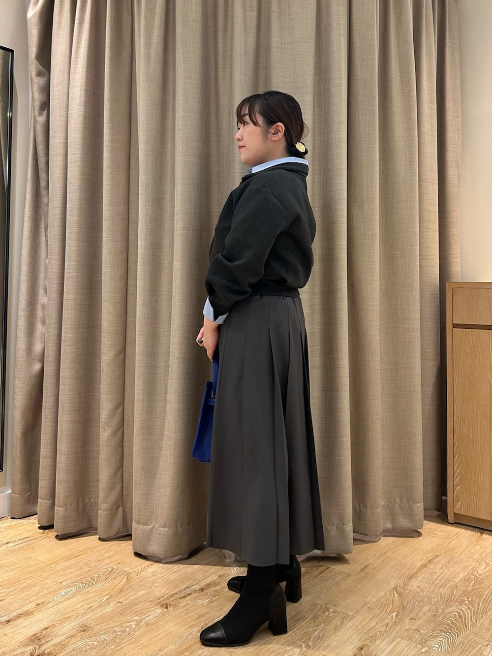 グレー系のブルゾン、ブルー系のシャツ/ブラウス、グレー系のスカートを着用したレディースの秋コーディネートの2枚目の写真