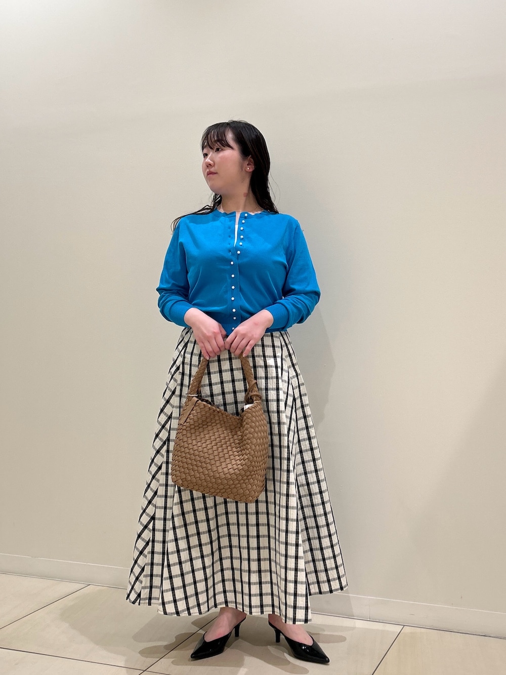 ブルー系のカーディガン/ボレロ、ホワイト系のスカート、ブラウン系のショルダーバッグを着用したレディースの春コーディネートの10枚目の写真