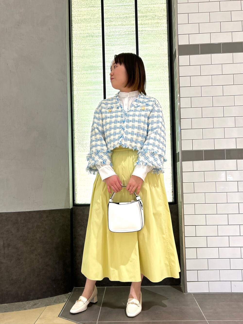 ブルー系のノーカラージャケット、ホワイト系のシャツ/ブラウス、ホワイト系のショルダーバッグを着用したレディースの冬コーディネートの2枚目の写真