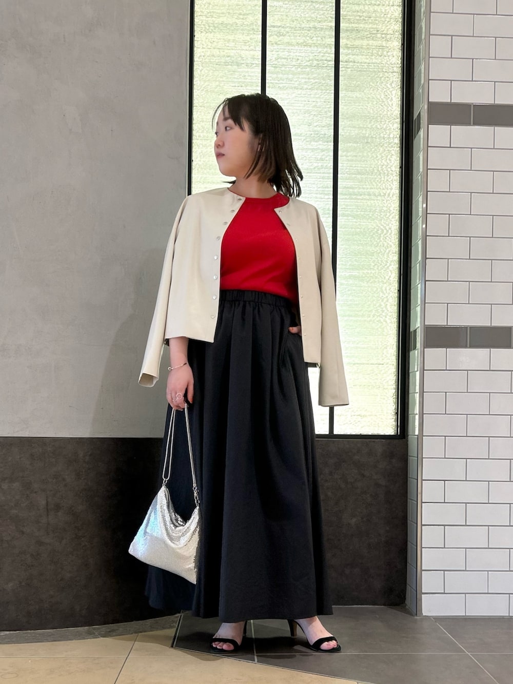 ベージュ系のブルゾン、レッド系のTシャツ/カットソー、ブラック系のスカートを着用したレディースの秋コーディネートの7枚目の写真