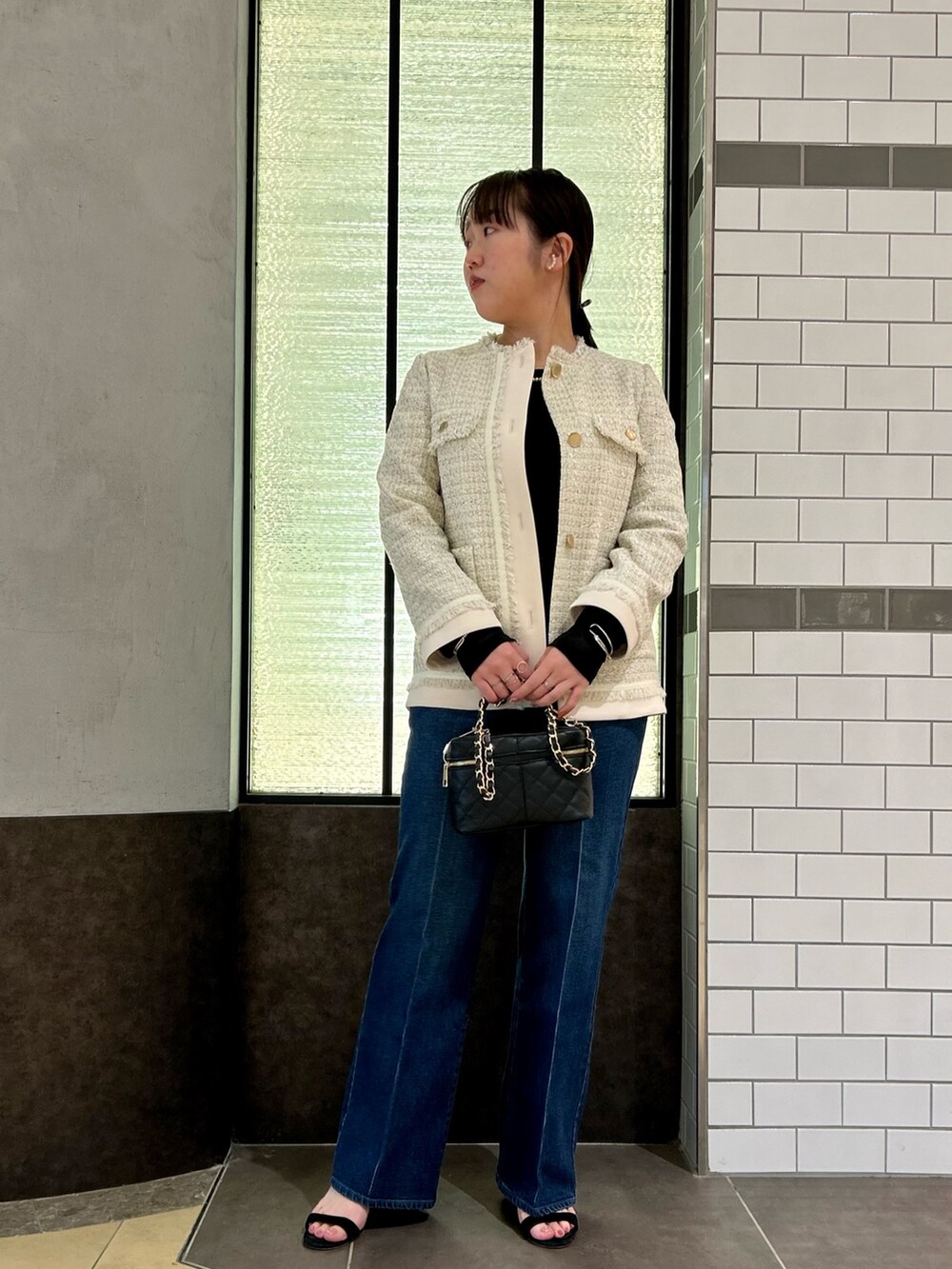 ホワイト系のノーカラージャケット、ブラック系のTシャツ/カットソー、ブルー系のデニムパンツを着用したレディースの夏コーディネートの7枚目の写真