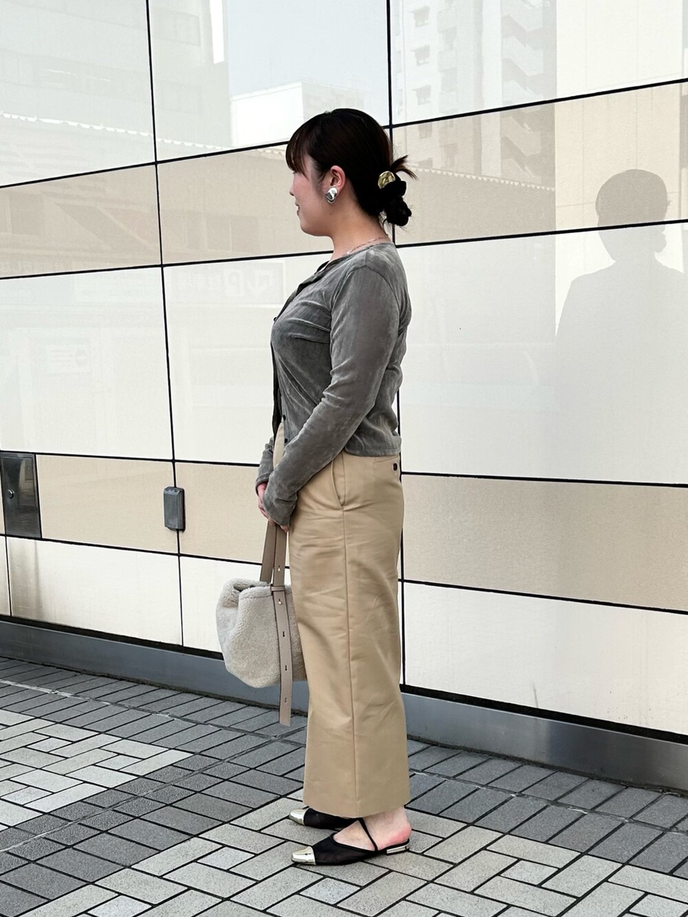 グレー系のカーディガン/ボレロ、ベージュ系のスカート、ベージュ系のショルダーバッグを着用したレディースの秋コーディネートの2枚目の写真