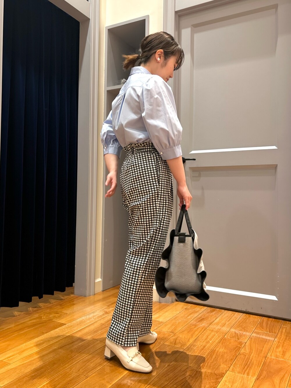 ブルー系のシャツ/ブラウス、ブラック系のその他パンツ、グレー系のトートバッグを着用したレディースの春コーディネートの6枚目の写真