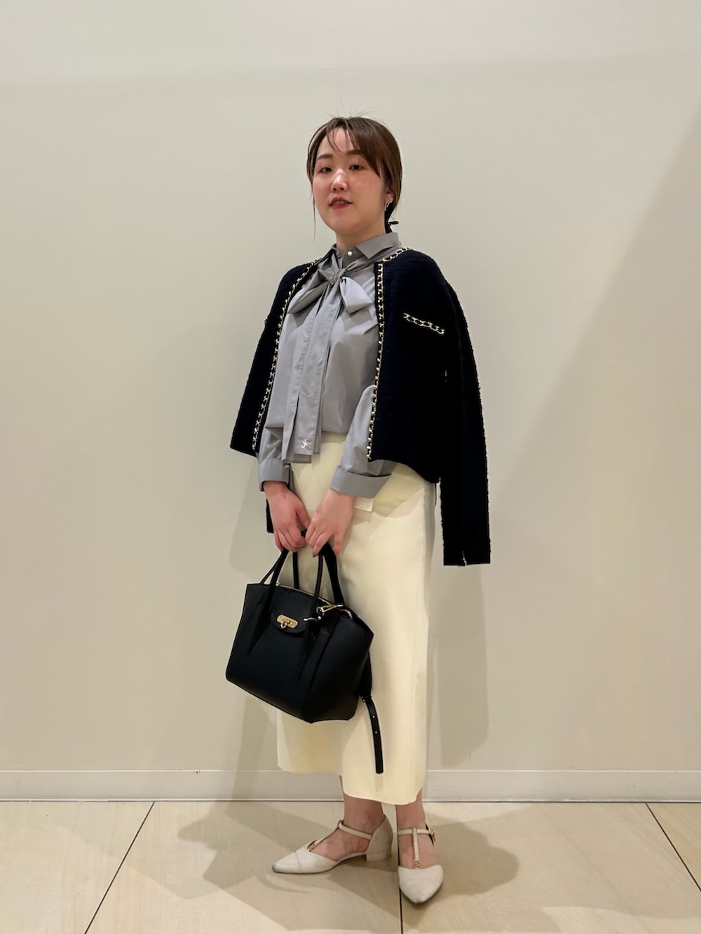 ブルー系のカーディガン/ボレロ、グレー系のシャツ/ブラウス、ホワイト系のスカートを着用したレディースの秋コーディネートの8枚目の写真